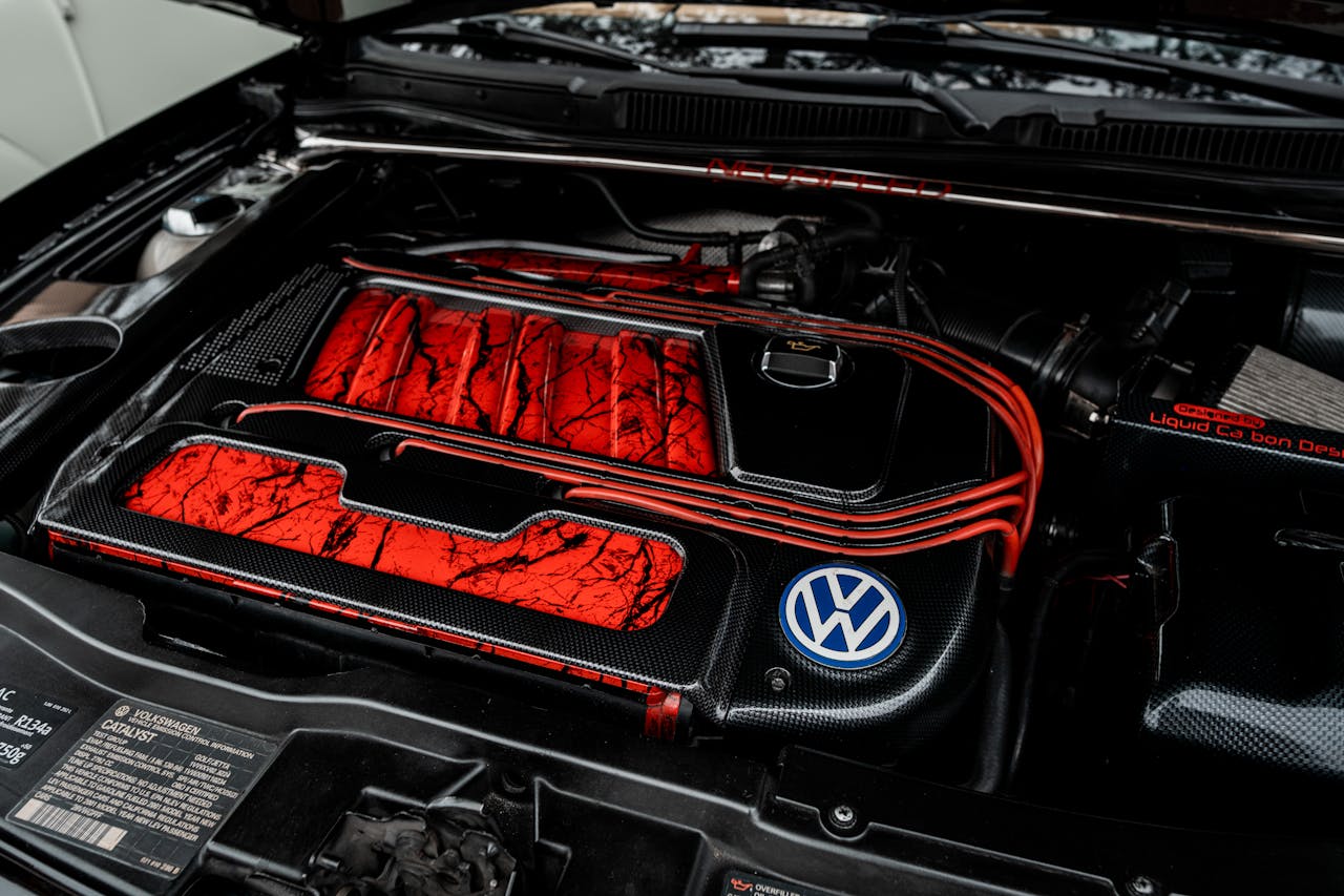 Close-up view of a Volkswagen car engine with a custom red design, highlighting unique details and branding.
